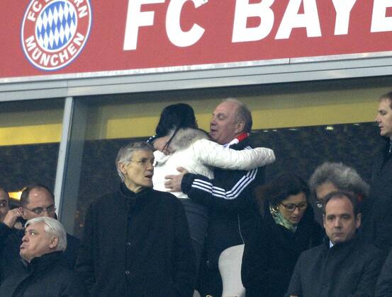 11.03.2014, Fussball Champions League 2013 2014, Achtelfinale, FC Bayern München - FC Arsenal London, in der Allianzarena München. Präsident Uli Hoeneß (re.oben, München, Höness, Höneß, Hoeness, Hoeneß) umarmt auf der Ehrentribüne Anne Kroehl, Lebensgefährtin von Karl Hopfner vor dem Spiel. 