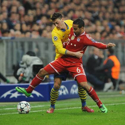 Thiago Alcantara (FC Bayern München) im Duell mit Mesut Özil (FC Arsenal) hinten. Bayern München - FC Arsenal, Champions League, Achtelfinale, Fussball, 11.03.2014,