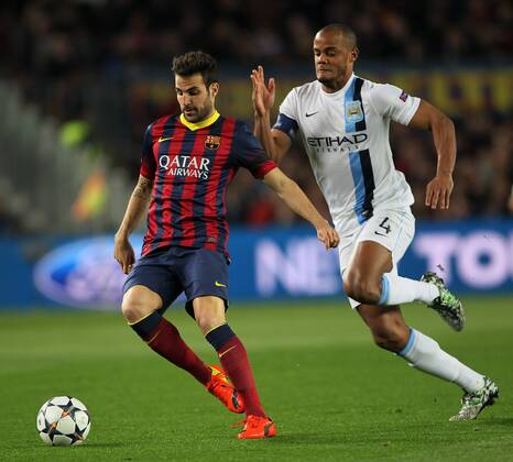 Barcelona s Cesc Fabregas tussles with Manchester City s Vincent Kompany Barcelona v Manchester City - Champions League last 16, second leg - Nou Camp - Barcelona - Spain - 12 03 2014 - Pic David Klein Sportimage EDITORIAL USE ONLY. No use with unauthorised audio, video, data, fixture lists, club league logos or live services. Online in-match use limited to 120 images, no video emulation. No use in betting, games or single club league player publications.