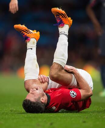 Robin van Persie of Manchester United holds his leg before being taken off injured - UEFA Champions League Round of 16 - Manchester United vs. Olympiacos - Old Trafford - Manchester - England - 19th March 2014 - Picture Philip Oldham Sportimage EDITORIAL USE ONLY. No use with unauthorised audio, video, data, fixture lists, club league logos or live services. Online in-match use limited to 120 images, no video emulation. No use in betting, games or single club league player publications.