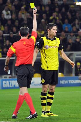 Borussia Dortmund vs. Zenit St. Petersburg --- Fussball --- Champions League --- 19.03.2014 Gelbe Karte, von links: Alberto Undiano Mallenco (Schiedsrichter), Robert Lewandowski (Dortmund), Gestik, Freisteller