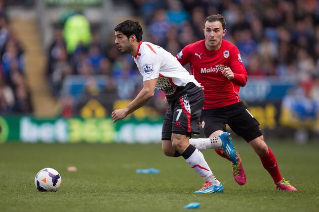 Luis Suarez of Liverpool escapes Cardiff s Jordan Mutch - Barclays Premier League - Cardiff City vs. FC Liverpool - Cardiff City Stadium - Cardiff - Wales - 22nd March 2014 - EDITORIAL USE ONLY. No use with unauthorised audio, video, data, fixture lists, club league logos or live services. Online in-match use limited to 120 images, no video emulation. No use in betting, games or single club league player publications.