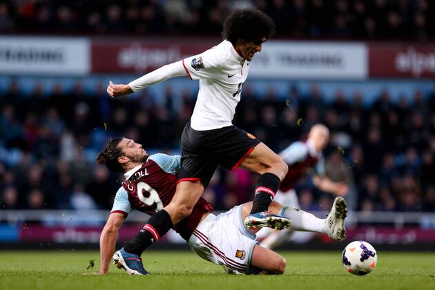 West Ham s Andy Carroll tackles Manchester United s Marouane Fellaini - West Ham United v Manchester United (ManU) - Barclays Premier League - Upton Park Stadium - London - 22nd March 2014 - EDITORIAL USE ONLY. No use with unauthorised audio, video, data, fixture lists, club league logos or live services. Online in-match use limited to 120 images, no video emulation. No use in betting, games or single club league player publications.