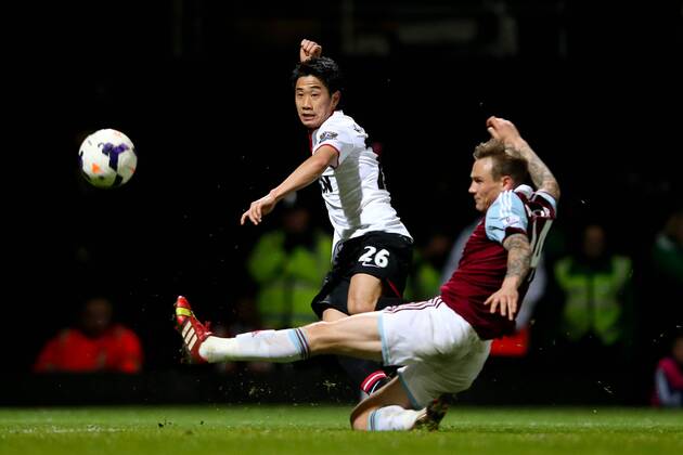 Manchester United s Shinji Kagawa puts in a cross under pressure from West Ham s Matt Taylor - West Ham United v Manchester United (ManU) - Barclays Premier League - Upton Park Stadium - London - 22nd March 2014 - EDITORIAL USE ONLY. No use with unauthorised audio, video, data, fixture lists, club league logos or live services. Online in-match use limited to 120 images, no video emulation. No use in betting, games or single club league player publications.