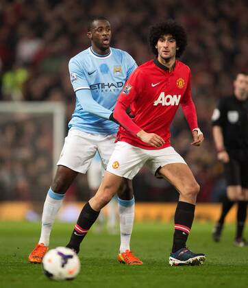 Yaya Toure of Manchester City and Marouane Fellaini of Manchester United - Barclays Premier League - Manchester United vs. Manchester City - Old Trafford - Manchester - England - 25th March 2014 - Picture Philip Oldham Sportimage EDITORIAL USE ONLY. No use with unauthorised audio, video, data, fixture lists, club league logos or live services. Online in-match use limited to 120 images, no video emulation. No use in betting, games or single club league player publications.