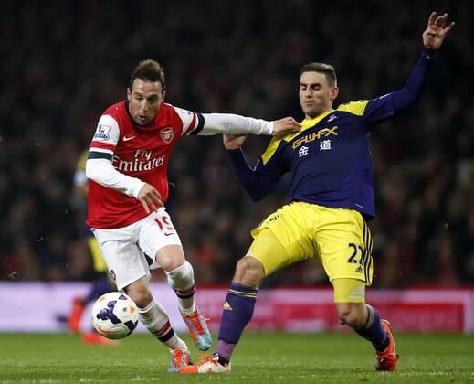 Santiago Cazorla (L) of Arsenal vies with Angel Rangel of Swansea City during the Barclays Premier League match between Arsenal and Swansea City at Emirates Stadium in London, Britain on Mar. 25, 2014. The match ended with a 2-2 draw. (Xinhua Wang Lili) FOR EDITORIAL USE ONLY. NOT FOR SALE FOR MARKETING OR ADVERTISING CAMPAIGNS. NO USE WITH UNAUTHORIZED AUDIO, VIDEO, DATA, FIXTURE LISTS, CLUB LEAGUE LOGOS OR LIVE SERVICES. ONLINE IN-MATCH USE LIMITED TO 45 IMAGES, NO VIDEO EMULATION. NO USE IN BETTING, GAMES OR SINGLE CLUB LEAGUE PLAYER PUBLICATIONS. (SP)BRITAIN-LONDON-SOCCER-PREMIER LEAGUE-ARSENAL VS SWANSEA CITY 