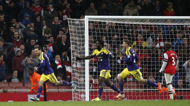 Leon Britton (1st L) of Swansea City celebrates after Arsenal s Mathieu Flamini s 90th-minute own goal during the Barclays Premier League match between Arsenal and Swansea City at Emirates Stadium in London, Britain on Mar. 25, 2014. The match ended with a 2-2 draw. (Xinhua Wang Lili) FOR EDITORIAL USE ONLY. NOT FOR SALE FOR MARKETING OR ADVERTISING CAMPAIGNS. NO USE WITH UNAUTHORIZED AUDIO, VIDEO, DATA, FIXTURE LISTS, CLUB LEAGUE LOGOS OR LIVE SERVICES. ONLINE IN-MATCH USE LIMITED TO 45 IMAGES, NO VIDEO EMULATION. NO USE IN BETTING, GAMES OR SINGLE CLUB LEAGUE PLAYER PUBLICATIONS. (SP)BRITAIN-LONDON-SOCCER-PREMIER LEAGUE-ARSENAL VS SWANSEA CITY 