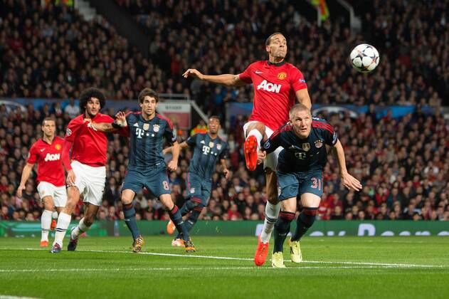 Rio Ferdinand of Manchester United (ManU) defends against Bastian Schweinsteiger of Munich - UEFA Champions League - Manchester United (ManU) vs. Bayern Munich FC - Old Trafford - Manchester - - 1st April 2014 - Picture PhilipxOldham Sportimage EDITORIAL USE ONLY. No use with unauthorised audio, video, data, fixture lists, club league logos or live services. Online in-match use limited to 120 images, no video emulation. No use in betting, games or single club league player publications.