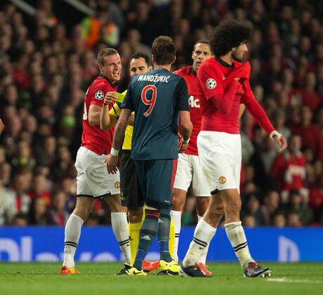 Nemanja Vidic of Manchester United (ManU) exchanges words with Mario Mandzukic of Munich - UEFA Champions League - Manchester United (ManU) vs. Bayern Munich FC - Old Trafford - Manchester - - 1st April 2014 - Picture PhilipxOldham Sportimage EDITORIAL USE ONLY. No use with unauthorised audio, video, data, fixture lists, club league logos or live services. Online in-match use limited to 120 images, no video emulation. No use in betting, games or single club league player publications.