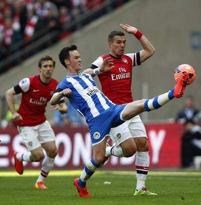 Josh McEachran (C) of Wigan Athletic vies with Lukas Podolski of Arsenal during FA Cup semifinal match between Arsenal and Wigan Athletic at Wembley Stadium in London, Britain, on April 12, 2014. Arsenal advanced to the final with winning 4-2 on penalties after a 1-1 draw. (Xinhua Wang Lili) FOR EDITORIAL USE ONLY. NOT FOR SALE FOR MARKETING OR ADVERTISING CAMPAIGNS. NO USE WITH UNAUTHORIZED AUDIO, VIDEO, DATA, FIXTURE LISTS, CLUBLEAGUE LOGOS OR LIVE SERVICES. ONLINE IN-MATCH USE LIMITED TO 45 IMAGES, NO VIDEO EMULATION. NO USE IN BETTING, GAMES OR SINGLE CLUBLEAGUEPLAYER PUBLICATIONS. (SP)BRITAIN-LONDON-SOCCER-FA CUP-ARSENAL VS WIGAN 