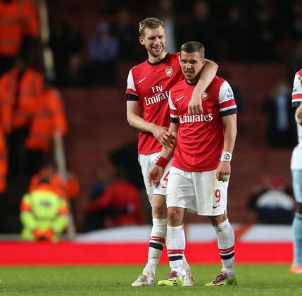 Arsenal s Lukas Podolski celebrates at the final whistle with Per Mertesacker Arsenal vs West Ham United- Barclays Premier League - Emirates Stadium - London - England - 15 04 2014 - Pic David Klein Sportimage EDITORIAL USE ONLY. No use with unauthorised audio, video, data, fixture lists, club league logos or live services. Online in-match use limited to 120 images, no video emulation. No use in betting, games or single club league player publications.