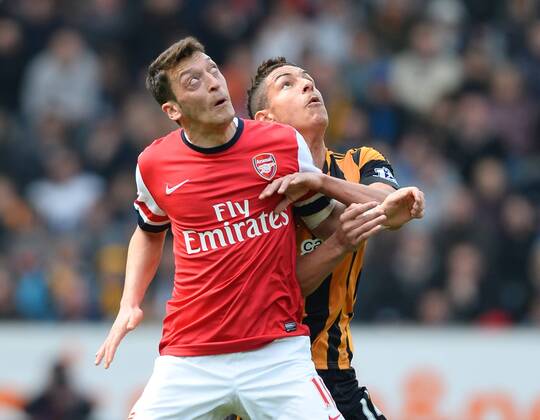 Mesut Ozil of Arsenal tussles with Jake Livermore of Hull City - Barclays Premier League - Hull City v Arsenal - KC Stadium - Hull - England - 20th April 2014 - Pic Simon Bellis Sportimage EDITORIAL USE ONLY. No use with unauthorised audio, video, data, fixture lists, club league logos or live services. Online in-match use limited to 120 images, no video emulation. No use in betting, games or single club league player publications.