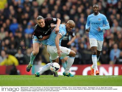 Football - 2013 2014 Premier League - Manchester City vs. West Ham United Manchester City s Vincent Kompany and West Ham s Andy Caroll in action at the Etihad Stadium, Manchester 