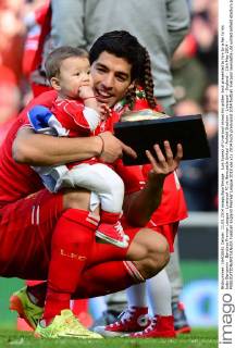 Luis Suarez of Liverpool shows his golden boot presented to him by a fan to his baby Benjamin - Barclays Premier League - Liverpool FC vs Newcastle United - Anfield Stadium - Liverpool - England - 11th May 2014 - EDITORIAL USE ONLY. No use with unauthorised audio, video, data, fixture lists, club league logos or live services. Online in-match use limited to 120 images, no video emulation. No use in betting, games or single club league player publications.