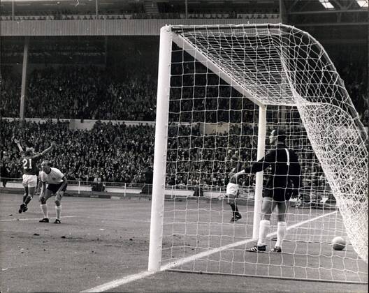 Fußball, WM 1966, Finale in Wembley, England - Deutschland 4-2 n.V. Jul. 30, 1966 - World Cup Football England versus West Germany World Cup Final at Wembley, London. Photo Shows: Rogert Hunt, of England raises his arms in delight as Hurst scores Englands first goal, next to him Willi Schulz (seen through net beside German goalie Hans Tilkowski)  - ZUMAk09
