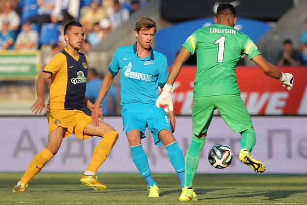 ITAR-TASS: ST. PETERSBURG, RUSSIA. AUGUST 6, 2014. Zenit s goalkeeper Yuri Lodygin and Nicolas Lombaerts (R-L) in action in the UEFA Champions League 3rd Qualifying Round match against FC AEL (Limassol, Cyprus) at the Petrovsky Stadium in St. Petersburg. FC Zenit St Petersburg wins the game 3:0.  premiumd 20211411
