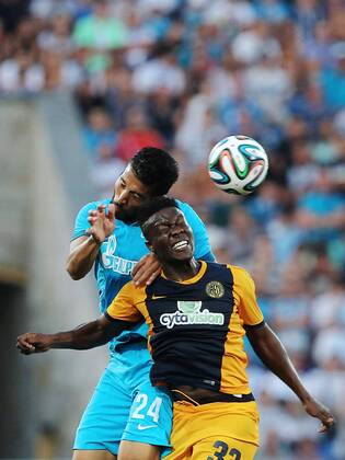 ITAR-TASS: ST. PETERSBURG, RUSSIA. AUGUST 6, 2014. Zenit s Ezequiel Garay (L) and AEL s Diallo Guidileye fight for the ball in their second leg of the 2014 15 Season UEFA Champions League Third Qualifiying Round football match at Petrovsky Stadium. FC Zenit won the game 3:0.  1 RE14C50D