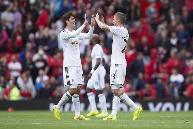 Swansea s Ki Sung-yueng and Gylfi Sigurdsson celebrate victory - Manchester United vs. Swansea - Barclays Premier League - Old Trafford - Manchester - 16 08 2014 Pic Philip Oldham Sportimage EDITORIAL USE ONLY. No use with unauthorised audio, video, data, fixture lists, club league logos or live services. Online in-match use limited to 120 images, no video emulation. No use in betting, games or single club league player publications.