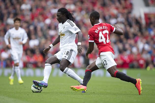 Tyler Blackett of Manchester United closes down Swansea s Bafetimbi Gomis - Manchester United vs. Swansea - Barclays Premier League - Old Trafford - Manchester - 16 08 2014 Pic Philip Oldham Sportimage EDITORIAL USE ONLY. No use with unauthorised audio, video, data, fixture lists, club league logos or live services. Online in-match use limited to 120 images, no video emulation. No use in betting, games or single club league player publications.