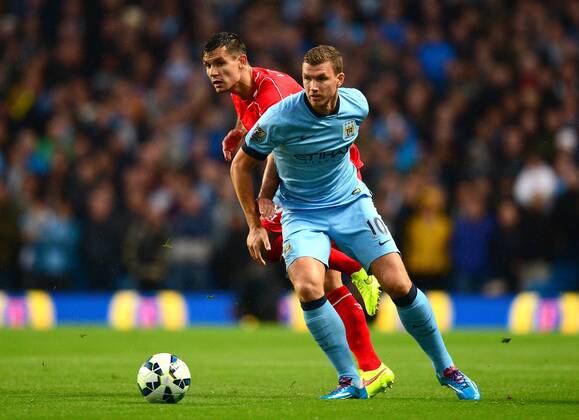 Edin Dzeko of Manchester City holds off Dejan Lovren of Liverpool - Barclays Premier League - Manchester City vs Liverpool - Etihad Stadium - Manchester - England - 25th August 2014 - Pic Simon Bellis Sportimage EDITORIAL USE ONLY. No use with unauthorised audio, video, data, fixture lists, club league logos or live services. Online in-match use limited to 120 images, no video emulation. No use in betting, games or single club league player publications.