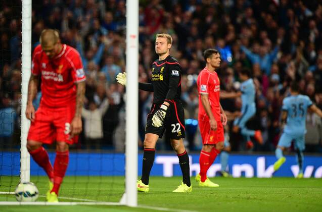 Simon Mignolet of Liverpool dejected as Sergio Aguero of Manchester City celebrates in the background - Barclays Premier League - Manchester City vs Liverpool - Etihad Stadium - Manchester - England - 25th August 2014 - Pic Simon Bellis Sportimage EDITORIAL USE ONLY. No use with unauthorised audio, video, data, fixture lists, club league logos or live services. Online in-match use limited to 120 images, no video emulation. No use in betting, games or single club league player publications.