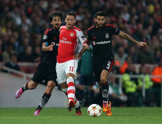 Arsenal s Mesut Ozil tussles wtih Besiktas Veli Kavlak and Ismail Koybasi - UEFA Champions League, Play-off Second Leg - Emirates Stadium - England - 27th August 2014 - Picture David Klein Sportimage EDITORIAL USE ONLY. No use with unauthorised audio, video, data, fixture lists, club league logos or live services. Online in-match use limited to 120 images, no video emulation. No use in betting, games or single club league player publications.
