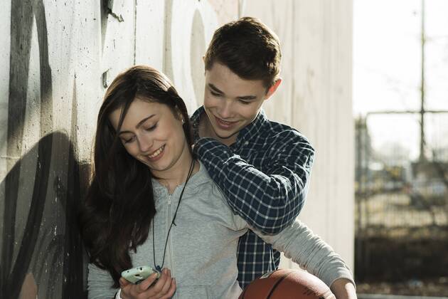 Teenage couple with basket ball and smartphone model released UUF000172