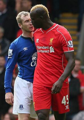 Mario Balotelli of Liverpool and Tony Hibbert of Everton clash - Barclays Premier League - Liverpool vs Everton - Anfield Stadium - Liverpool - England - 27th September 2014 - EDITORIAL USE ONLY. No use with unauthorised audio, video, data, fixture lists, club league logos or live services. Online in-match use limited to 120 images, no video emulation. No use in betting, games or single club league player publications.