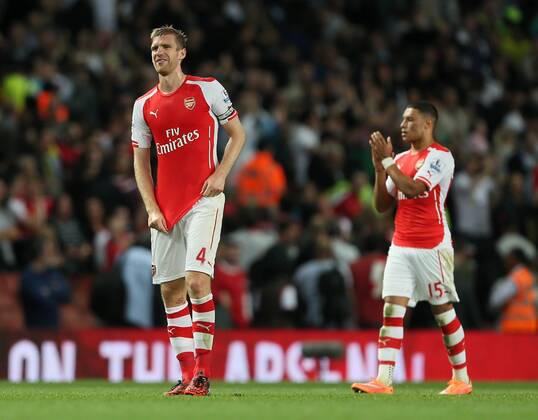 Arsenal s Per Mertesacker looks on dejected - Barclays Premier League - Arsenal vs Tottenham Hotspur - Emirates Stadium - England - 27th September 2014 - EDITORIAL USE ONLY. No use with unauthorised audio, video, data, fixture lists, club league logos or live services. Online in-match use limited to 120 images, no video emulation. No use in betting, games or single club league player publications.