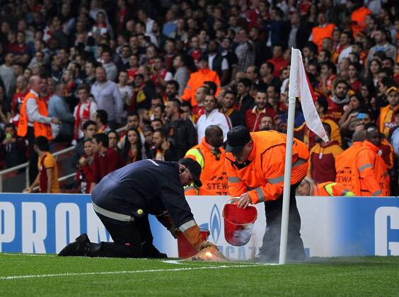 FC Arsenal s stewards put out a flare thrown onto the pitch - UEFA Champions League Group D - Arsenal - Emirates Stadium - England - 01st October 2014 - EDITORIAL USE ONLY. No use with unauthorised audio, video, data, fixture lists, club league logos or live services. Online in-match use limited to 120 images, no video emulation. No use in betting, games or single club league player publications.