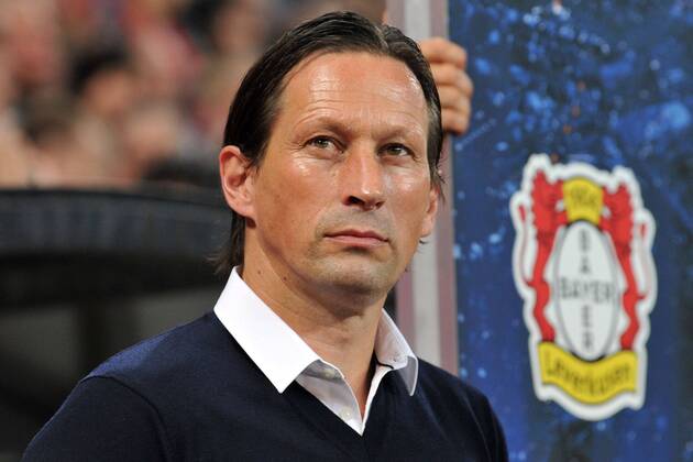 Bayer 04 Leverkusen vs. Benfica Lissabon --- Fussball --- Champions League --- 01.10.2014 Roger Schmidt (Trainer Leverkusen), im Hintergrund das Wappen von Bayer Leverkusen, Logo, Einzelbild, halbe Figur