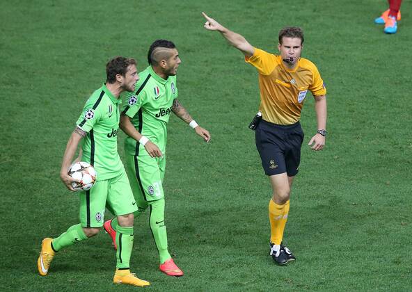 Juventus Claudio Marchisio (l) and Roberto Pereyra (c) have with the referee Felix Brych during Champions League 2014 2015 match.October 1,2014.  (20229574)