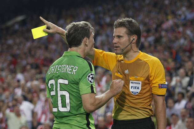 Referee shows a yellow card to Juventus s Lichtsteiner during Champions League soccer match between Atletico de Madrid and Juventus at Vicente Calderon stadium in Madrid, Spain. October 01, 2014.  (20229604)