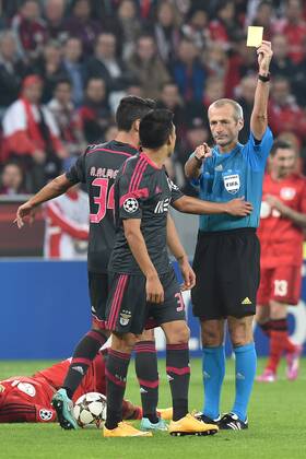 Fußball Champions League Gruppenphase Bayer Leverkusen - Benfica Lissabon am 01.10.2014 in der BayArena in Leverkusen FIFA-Schiedsrichter Martin Atkinson ( England ), hinten - zeigt Enzo Perez ( Lissabon ), vorne die gelbe Karte