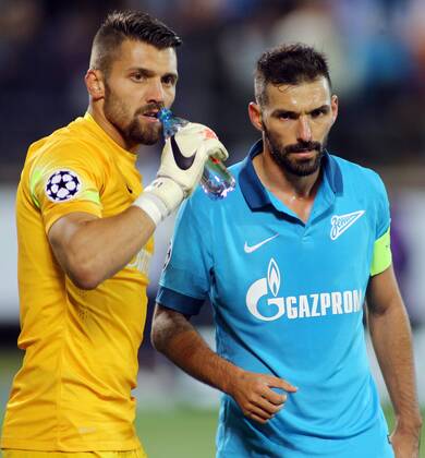 ST PETERSBURG, RUSSIA. OCTOBER 1, 2014. Zenitâ€™s goalie Yuri Lodygin drinks water in front of his team-mate Daniel Danny Miguel (R) in their UEFA Champions League Round 2 Group C football match against Monaco at Petrovsky Stadium. The game ended in a 0-0 draw. RuslanxShamukov TASS  RE150BBB