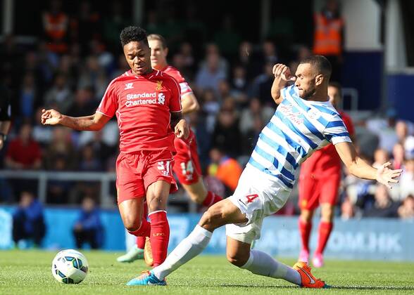 Football - 2014 2015 Premier League - Queens Park Rangers vs Liverpool, Steven Caulker of Queens Park Rangers gets a foot to the ball before Raheem Sterling of Liverpool FC at Loftus Road Colorsport Daniel Bearham QPR_LIV