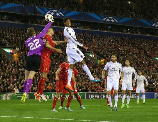 Simon Mignolet of Liverpool punches the ball clear as even Raphael Varane of Real Madrid gets in on the attack - UEFA Champions League Group B - Liverpool vs Real Madrid - Anfield Stadium - Liverpool- England - 22nd October 2014 - Picture Simon Bellis Sportimage EDITORIAL USE ONLY. No use with unauthorised audio, video, data, fixture lists, club league logos or live services. Online in-match use limited to 120 images, no video emulation. No use in betting, games or single club league player publications.