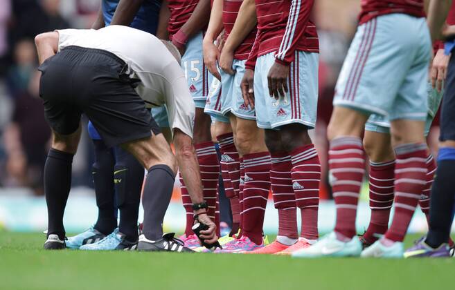 West Ham United v Manchester City . . London, UK . . 25.10.2014 Referee Martin Atkinson sprays the vanishing marking spray in front of the players boots.