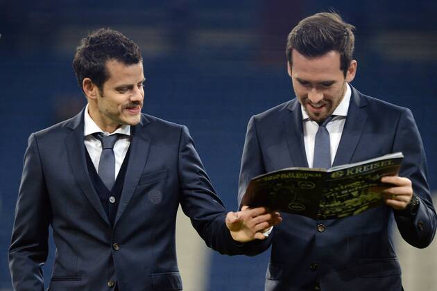 FC Schalke 04 vs. Chelsea London --- Fussball --- Champions League --- 25.11.2014 Tranquillo Barnetta (Schalke), links, und Christian Fuchs (Schalke) blicken in das Stadionheft Schalker Kreisel, privat, im Vereinsanzug, Freude, Stadionmagazin, Vereinsmagazin, halbe Figur