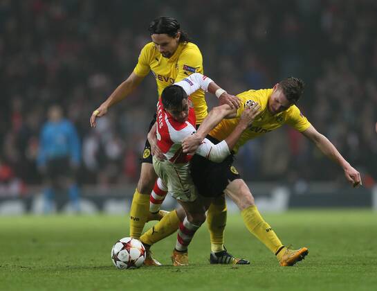 Arsenal s Alexis Sanchez tussles with Dortmund s Neven Subotic and Kevin Grosskreutz UEFA Champions League- Arsenal vs Borussia Dortmund- Emirates Stadium - England - 26th November 2014 - EDITORIAL USE ONLY. No use with unauthorised audio, video, data, fixture lists, club league logos or live services. Online in-match use limited to 120 images, no video emulation. No use in betting, games or single club league player publications.