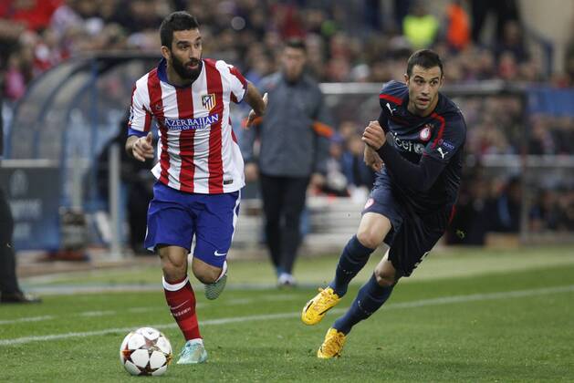 Atletico de Madrid s Arda Turan (L) and Olympiacos s Milivojevic during Champions League soccer match between Atletico de Madrid and Olympiacos at Vicente Calderon stadium in Madrid, Spain. November 26, 2014.  (2014112625925)