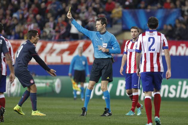 Referee Stark shows a yellow card to Olympiacos s Fuster during Champions League soccer match between Atletico de Madrid and Olympiacos at Vicente Calderon stadium in Madrid, Spain. November 26, 2014.  (2014112625962)