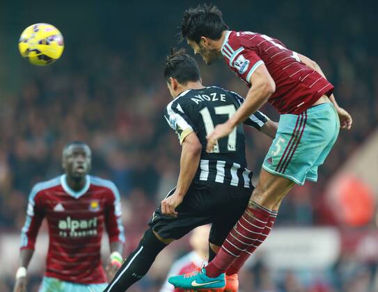 29.11.2014. London, England. Premier League. West Ham United versus Newcastle United from The Boelyn Ground. West Ham United defender James Tomkins wins a header from Newcastle United forward Ayoze Perez. xChakirxDahmanix  ActionPlus11579923