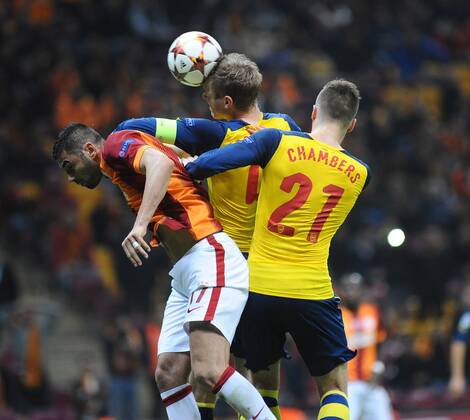 UEFA Champions League Group D match between Galatasaray and Arsenal at Turk Telekom Arena Stadium on December 09, 2014 in Istanbul, Turkey Pictured: Burak Yilmaz of Galatasaray and Per Mertesacker and Calum Chambers of Arsenal. 