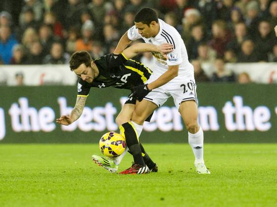 Football - 2014 2015 Premier League - Swansea City vs. Tottenham Hotspur Jefferson Montero of Swansea tackles Ryan Mason Tottenham of Hotspurs at The Liberty Stadium. COLORSPORT WINSTON BYNORTH