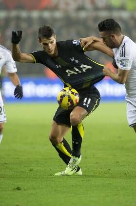 Football - 2014 2015 Premier League - Swansea City vs. Tottenham Hotspur Erik Lamela of Tottenham Hotspurs has his shirt held by Neil Taylor of Swansea at The Liberty Stadium. COLORSPORT WINSTON BYNORTH