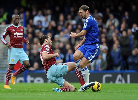 Andy Carroll of West Ham United tackles Branislav Ivanovic of Chelsea - Barclays Premier League - Chelsea vs West Ham United - Stamford Bridge Stadium - London - England - 26th December 2014 - Pic Robin Parker Sportimage EDITORIAL USE ONLY. No use with unauthorised audio, video, data, fixture lists, club league logos or live services. Online in-match use limited to 120 images, no video emulation. No use in betting, games or single club league player publications. DSC_7765