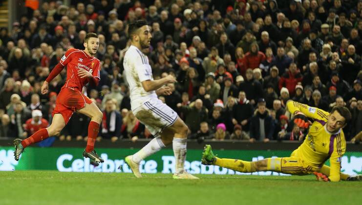 Adam Lallana of FC Liverpool scores the third goal past Lucas Fabianski of Swansea City - Barclays Premier League - FC Liverpool vs Swansea City - Anfield Stadium - Liverpool - England - 29th December 2014 - EDITORIAL USE ONLY. No use with unauthorised audio, video, data, fixture lists, club league logos or live services. Online in-match use limited to 120 images, no video emulation. No use in betting, games or single club league player publications.