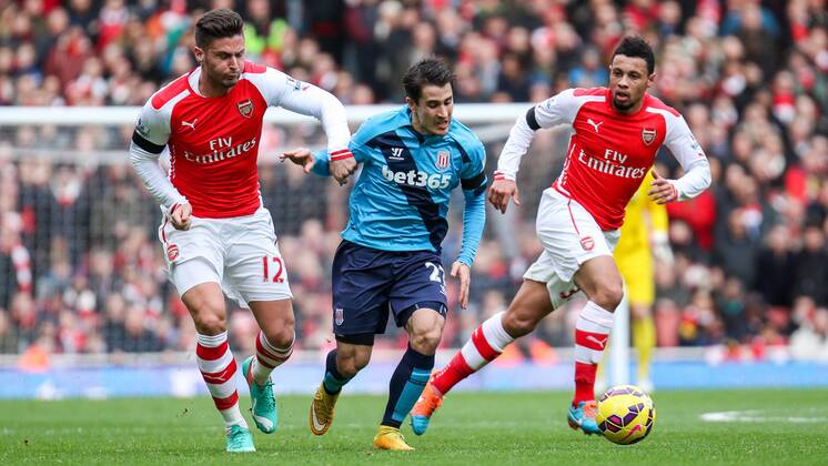 Football - 2014 2015 - Barclays Premier League, - Arsenal Vs Stoke City, Stoke City s Bojan Krkic is held back by Arsenal s Olivier Giroud at The Emirates Stadium COLORSPORT DANIEL BEARHAM ARS_STO
