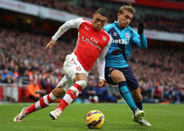 Football - 2014 2015 - Barclays Premier League, - Arsenal Vs Stoke City, Arsenal s Alex Oxlade-Chamberlain and Stoke City s Marc Muniesa at The Emirates Stadium COLORSPORT DANIEL BEARHAM ARS_STO